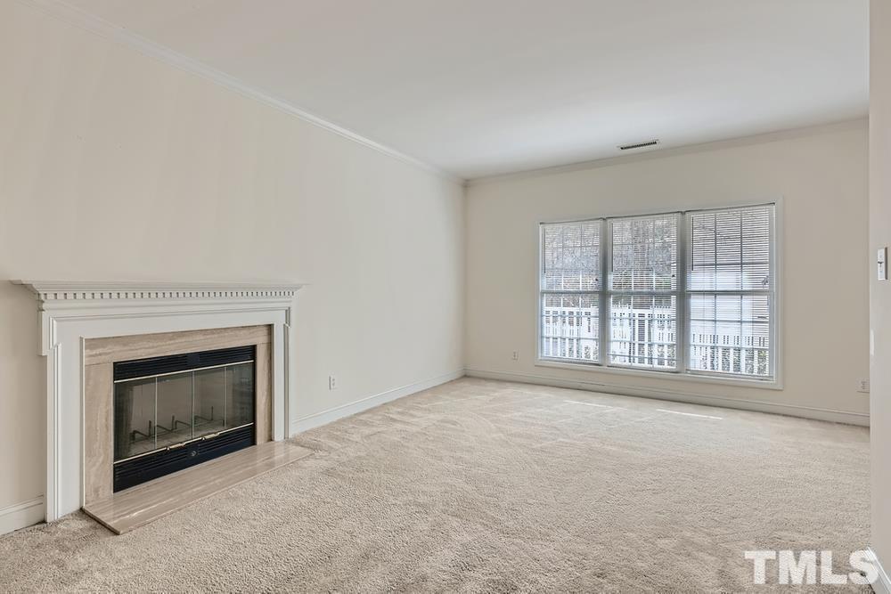 205 Bridgepath Drive Cary, NC 27513 - Photo 8 of 28 an empty room with a fireplace and windows