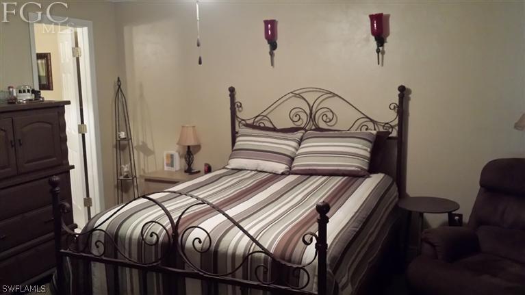 7436 Pebble Beach Road Fort Myers, FL 33967 - Photo 13 of 17 a bedroom with a bed a mirror and a dresser