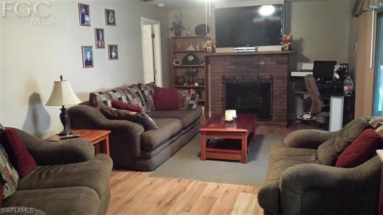 7436 Pebble Beach Road Fort Myers, FL 33967 - Photo 2 of 17 a living room with furniture and a fireplace