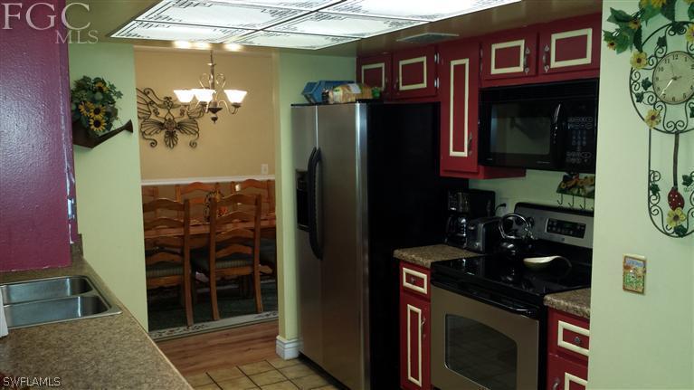7436 Pebble Beach Road Fort Myers, FL 33967 - Photo 6 of 17 a kitchen with stainless steel appliances granite countertop a refrigerator and a stove top oven