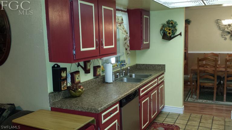 7436 Pebble Beach Road Fort Myers, FL 33967 - Photo 7 of 17 a kitchen with stainless steel appliances granite countertop a stove a sink and a microwave