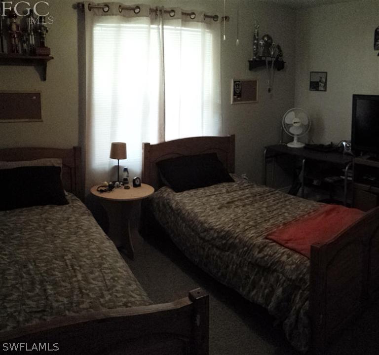 7436 Pebble Beach Road Fort Myers, FL 33967 - Photo 9 of 17 a bedroom with a bed and a table in it