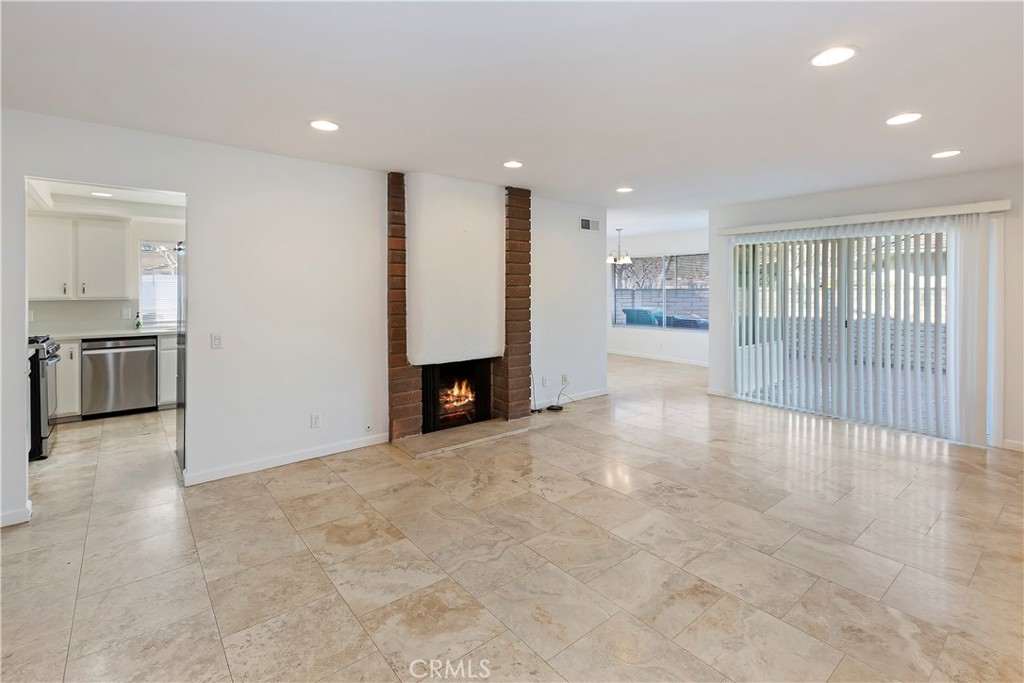 17241 Candleberry Irvine, CA 92612 - Photo 3 of 10 an empty room with kitchen view and a fireplace