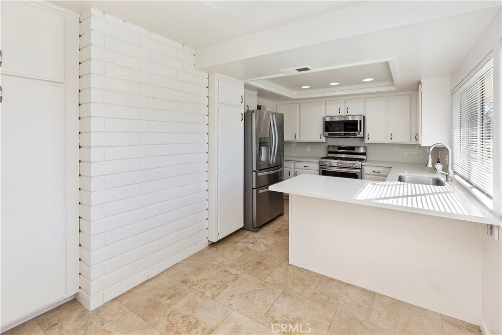 17241 Candleberry Irvine, CA 92612 - Photo 4 of 10 a kitchen with stainless steel appliances a refrigerator and a stove top oven