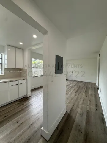 a view of a kitchen with wooden floor and electronic appliances