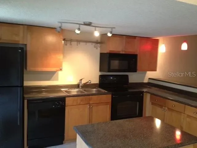 a kitchen with a sink a stove and a microwave