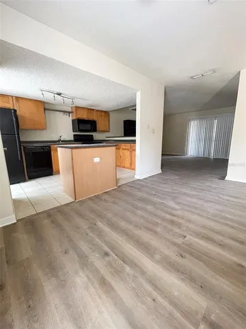 a view of kitchen with stainless steel appliances wooden floor