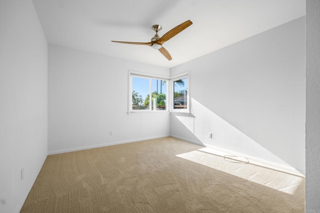 1592 Hawk View Drive Encinitas, CA 92024 - Photo 17 of 55 an empty room with windows and ceiling fan