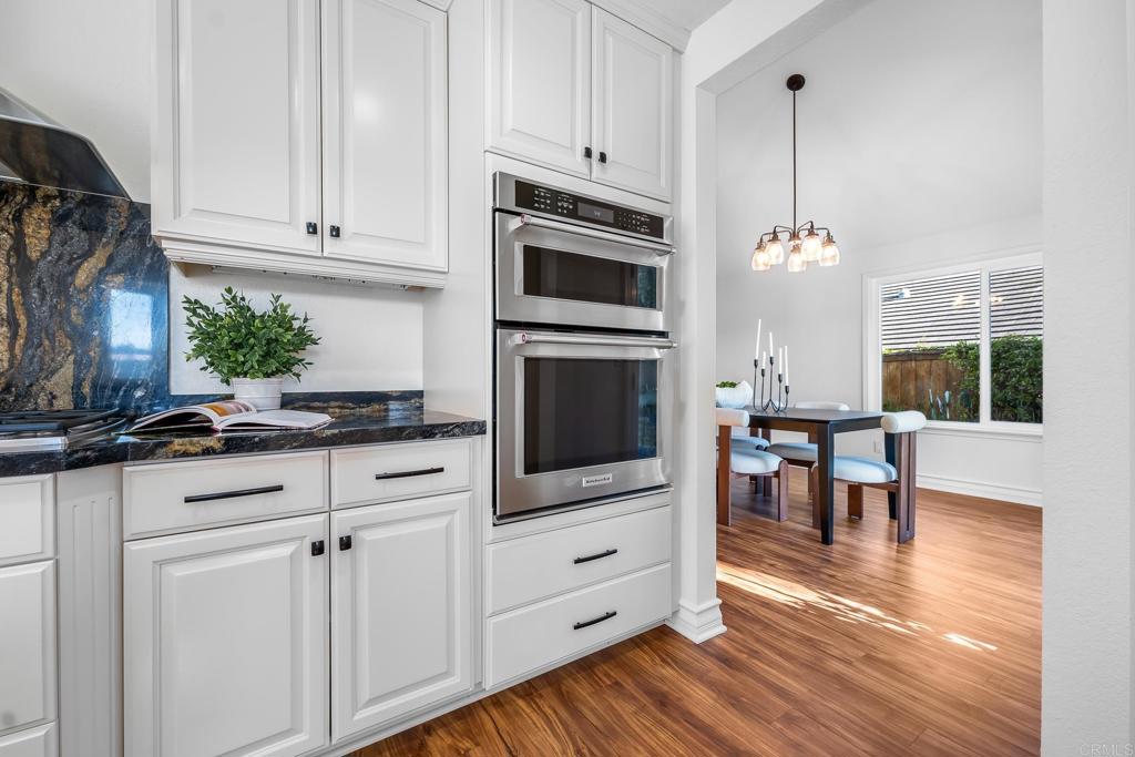 1592 Hawk View Drive Encinitas, CA 92024 - Photo 6 of 55 a kitchen with stainless steel appliances white cabinets and a wooden floor