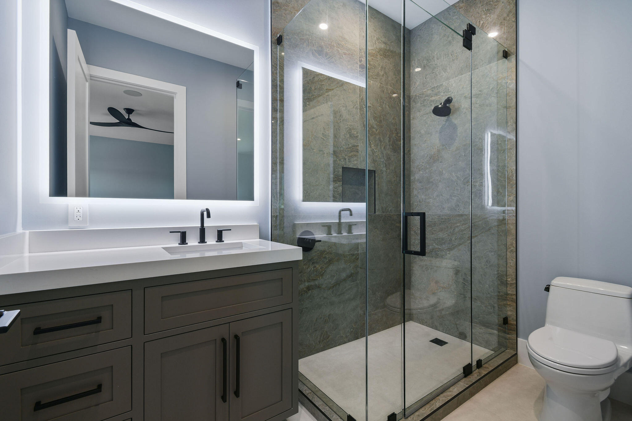 1060 Fairview Lane Singer Island, FL 33404 - Photo 52 of 82 a bathroom with a shower sink vanity and toilet