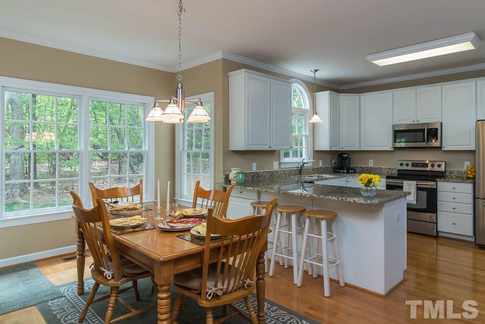 2908 Sunnystone Way Raleigh, NC 27613 - Photo 7 of 25 a kitchen with a table chairs and wooden floor