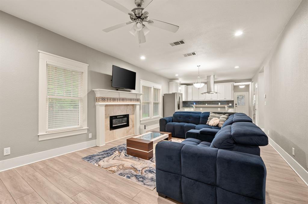 800 North Clements Street Gainesville, TX 76240 - Photo 7 of 27 a living room with furniture a flat screen tv and a fireplace