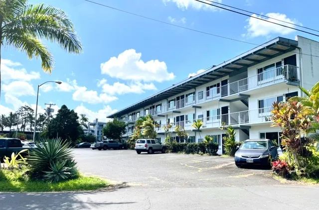 a front view of a house with garden and plants