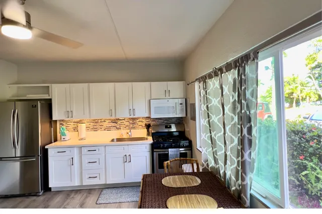 a kitchen with stainless steel appliances granite countertop a refrigerator sink and cabinets