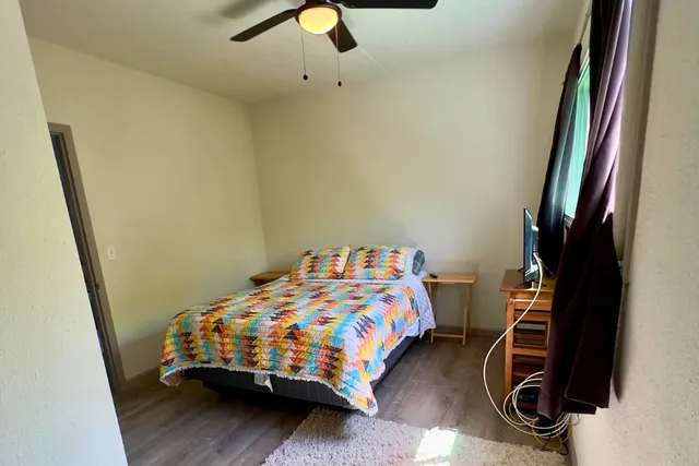 a bedroom with a bed and wooden floor