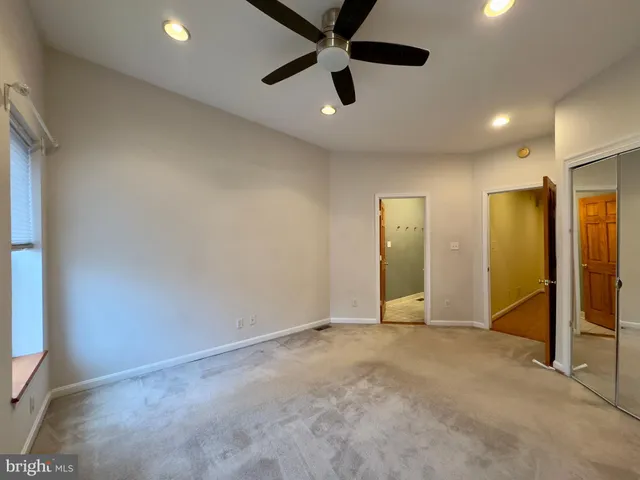an empty room with fan and entrance