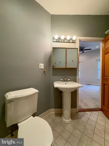 a bathroom with a sink toilet and mirror