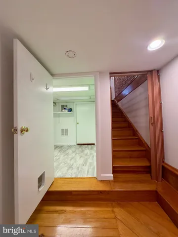 a view of a hallway with wooden floor and staircase