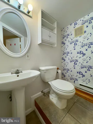 a bathroom with a sink toilet and mirror