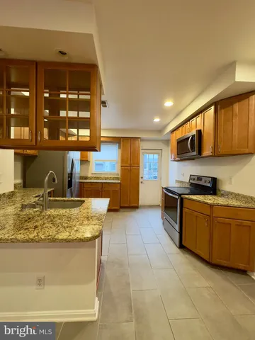 a kitchen with stainless steel appliances granite countertop a sink stove and cabinets