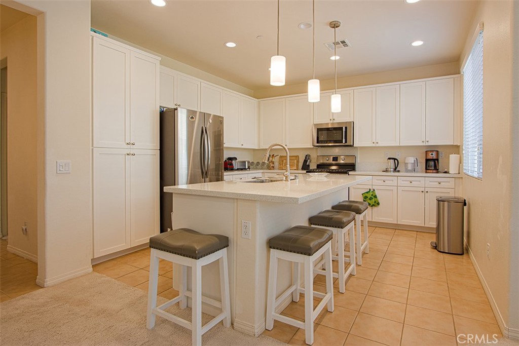 1509 Granada Road Upland, CA 91786 - Photo 5 of 31 a kitchen with stainless steel appliances kitchen island granite countertop a sink a stove a refrigerator cabinets and chairs