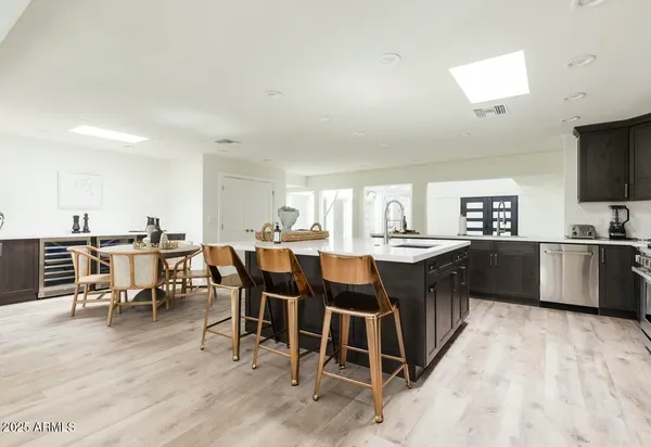 a kitchen with stainless steel appliances kitchen island granite countertop a sink stove and refrigerator