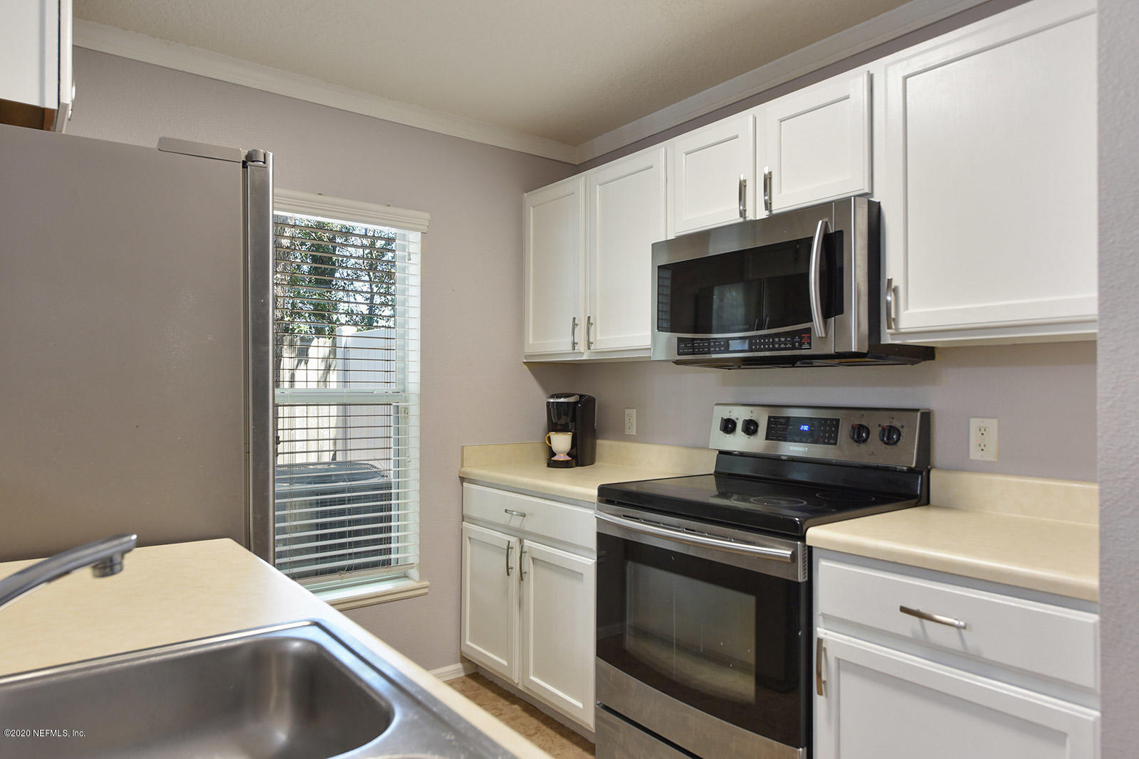10543 Autumn Trace Road Jacksonville, FL 32257 - Photo 13 of 25 a kitchen with stainless steel appliances a stove a microwave sink and cabinets