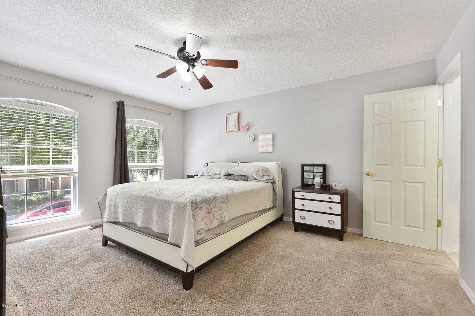 10543 Autumn Trace Road Jacksonville, FL 32257 - Photo 18 of 25 a large bed sitting in a bedroom next to a window and a chandelier