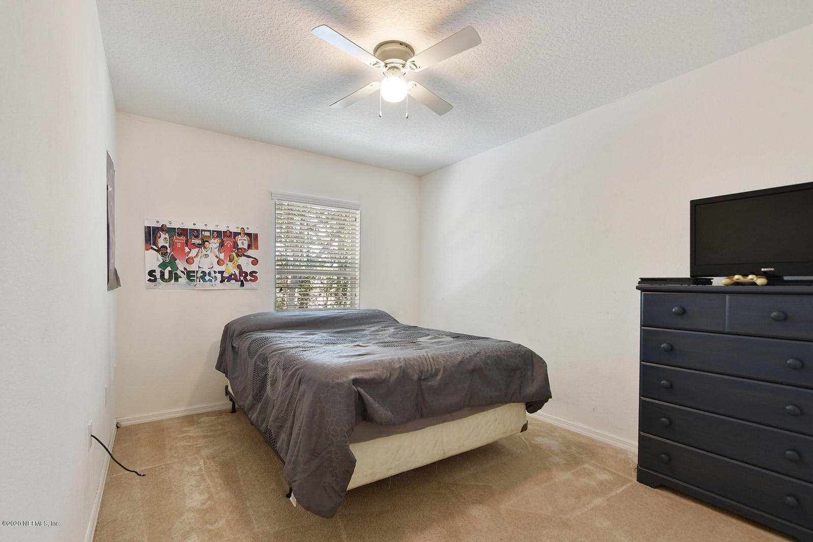 10543 Autumn Trace Road Jacksonville, FL 32257 - Photo 20 of 25 a bedroom with a bed and a flat tv screen on dresser