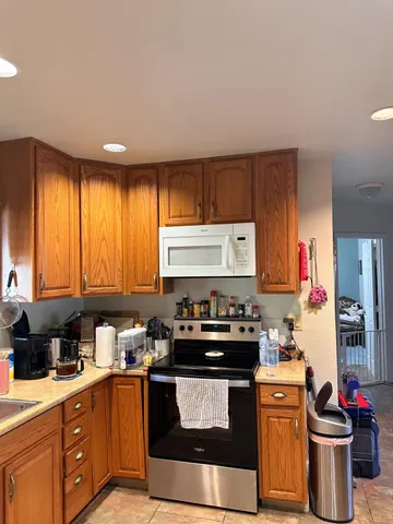 a kitchen with stainless steel appliances kitchen island granite countertop a sink stove and cabinets