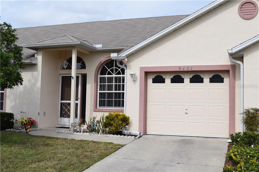 Front entry with arched windows and garage.