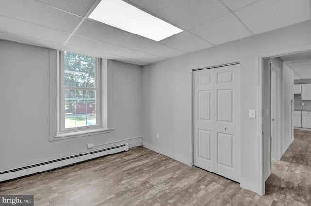 an empty room with wooden floor and mirror