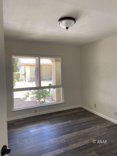1010 Peg Street Ridgecrest, CA 93555 - Photo 10 of 17 an empty room with wooden floor and windows