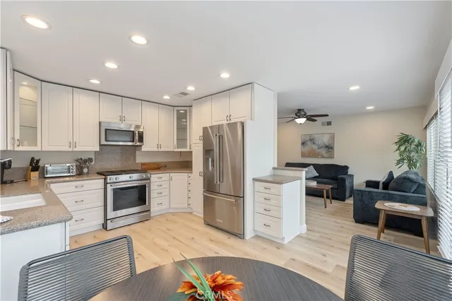 a kitchen with granite countertop a refrigerator stove top oven and sink