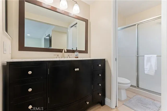 a bathroom with a double vanity sink toilet and mirror
