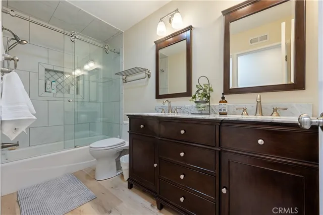 a bathroom with a double vanity sink toilet and shower