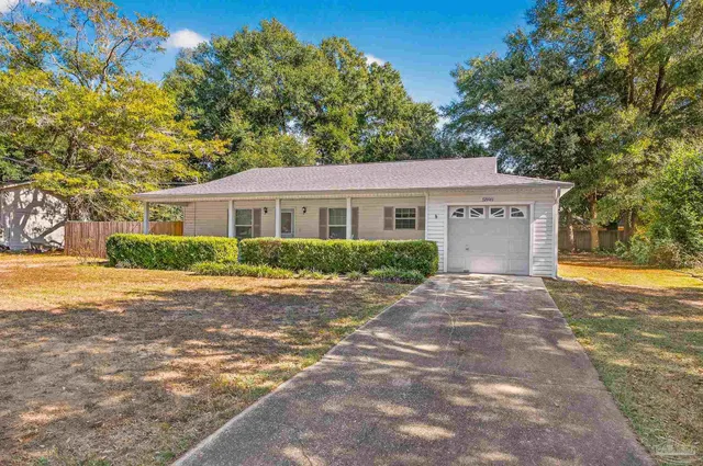a front view of a house with yard and trees