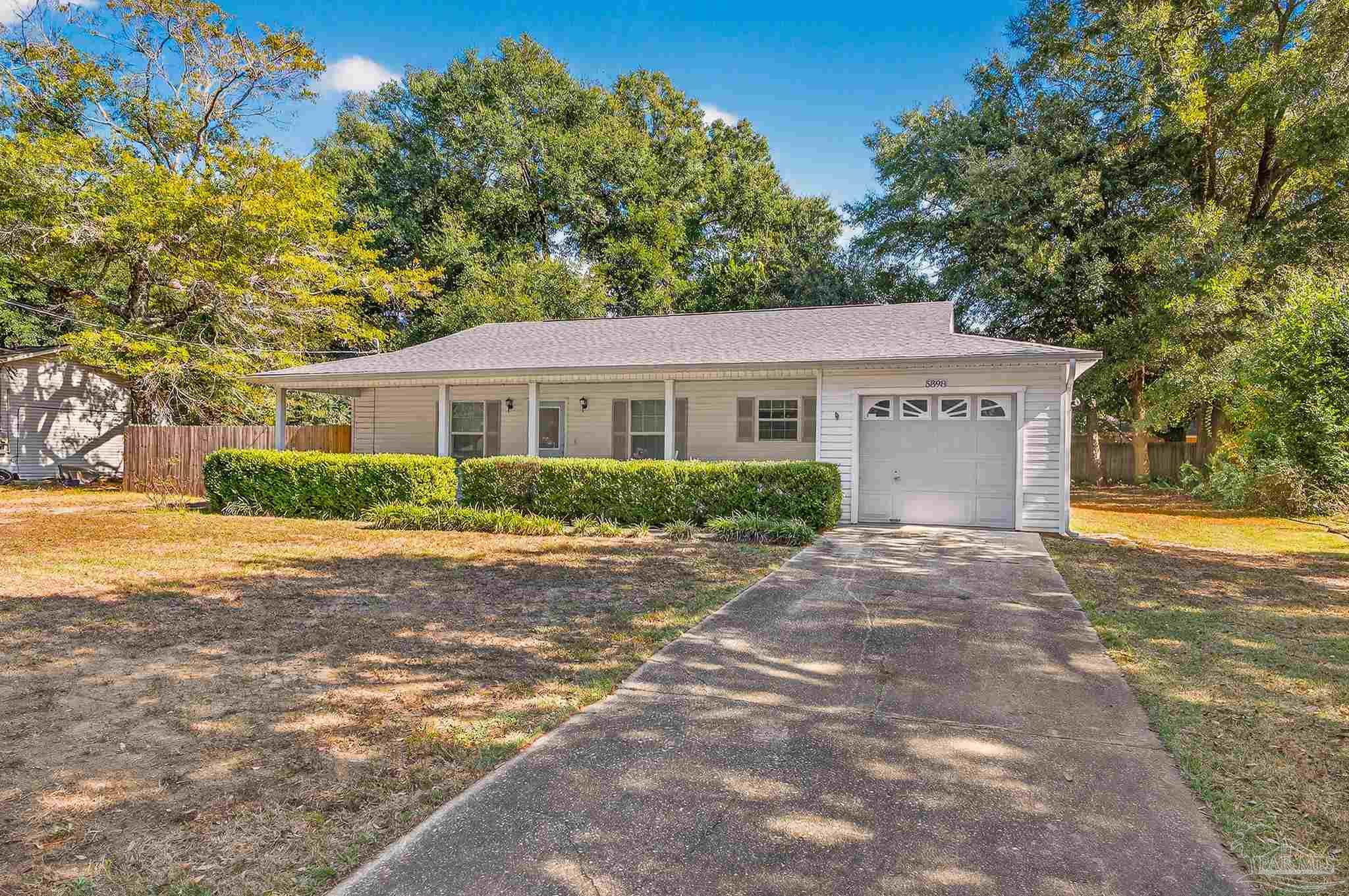 a front view of a house with yard and trees