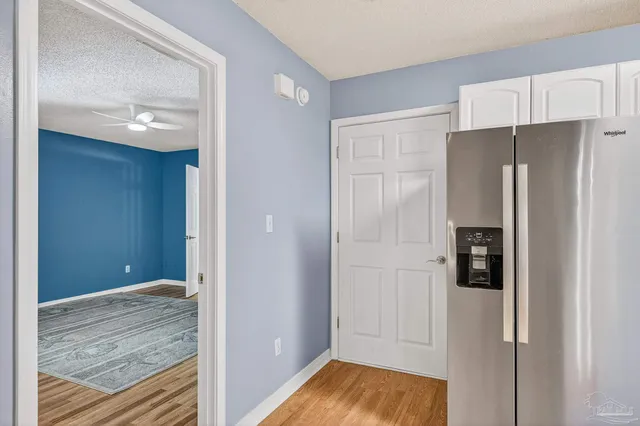 a view of kitchen with refrigerator cabinets and wooden floor