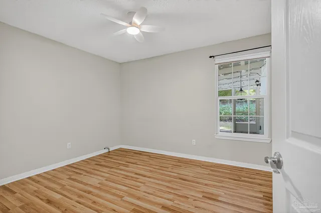 a view of a room with wooden floor and a ceiling fan