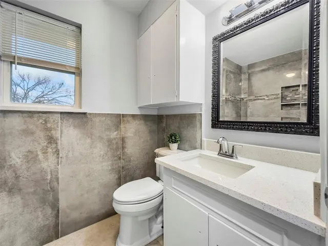 a bathroom with a sink a toilet and mirror