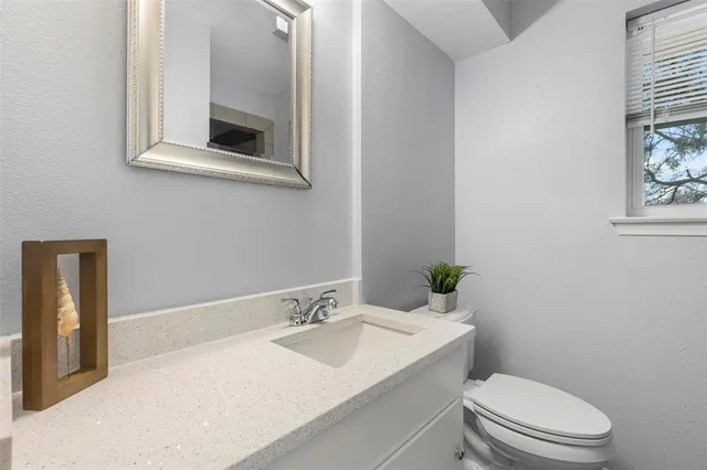 a bathroom with a toilet a sink and mirror
