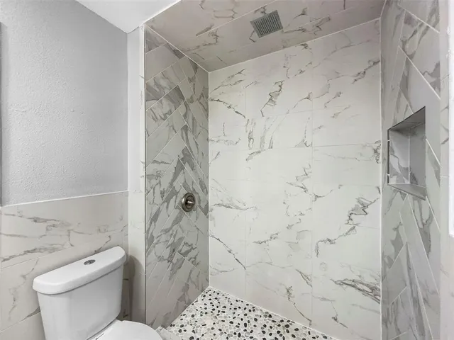 a bathroom with a toilet and a shower