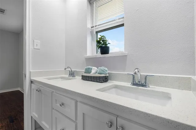 a bathroom with double sink and a mirror
