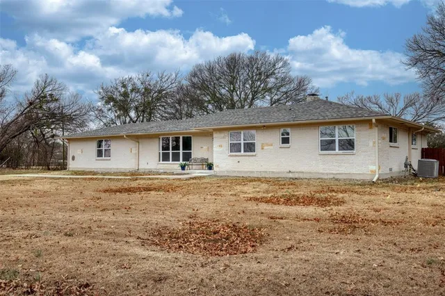 a front view of house with yard and trees