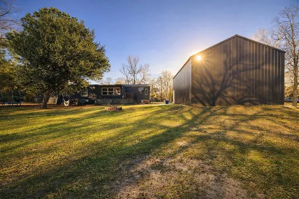 a view of swimming pool with outdoor seating and house in the background