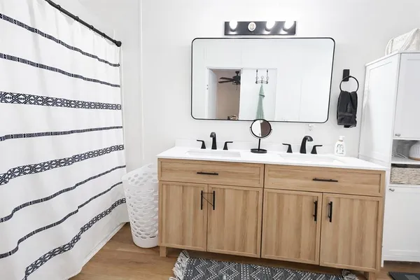 a bathroom with a double vanity sink a mirror and shower