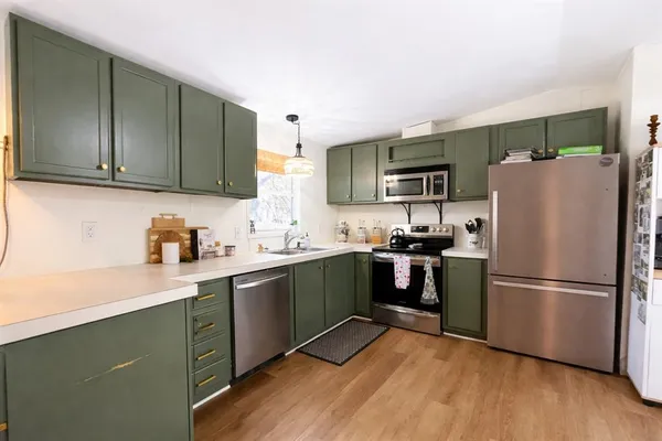 a kitchen with a refrigerator cabinets and wooden floor
