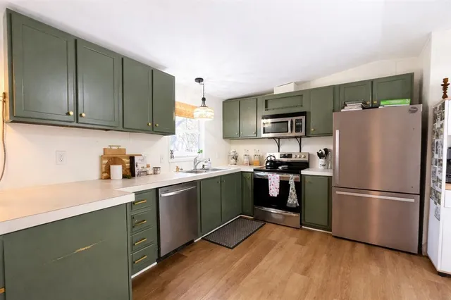 a kitchen with a refrigerator cabinets and wooden floor
