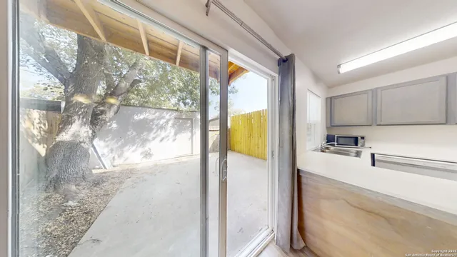 a view of a kitchen with a refrigerator sink and cabinets